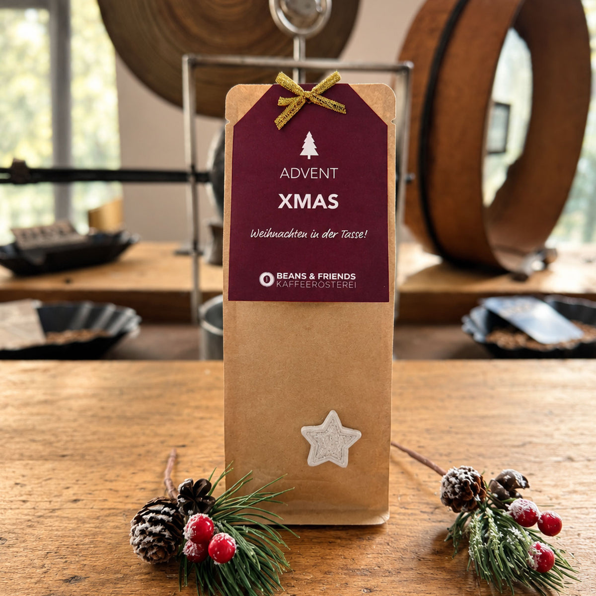Weihnachtliches Adventspaket von Beans & Friends (Tassenfilter - Drip Coffee) in einer braunen Geschenktüte mit dunkelrotem Anhänger und festlicher Dekoration.
