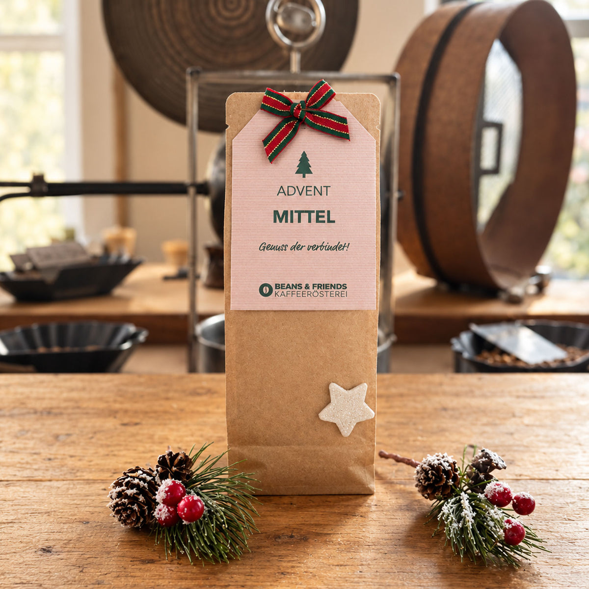 Beans & Friends Adventspaket Tassenfilter Drip Coffee mit der Geschmacksstärke mittel in einer braunen Geschenktüte mit rosafarbenem Anhänger und Weihnachtsdekoration.