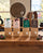 Vier Adventspakete (Tassenfilter - Drip Coffee) von Beans & Friends in braunen Geschenktüten mit verschiedenfarbigen Anhängern auf einem Holztisch.