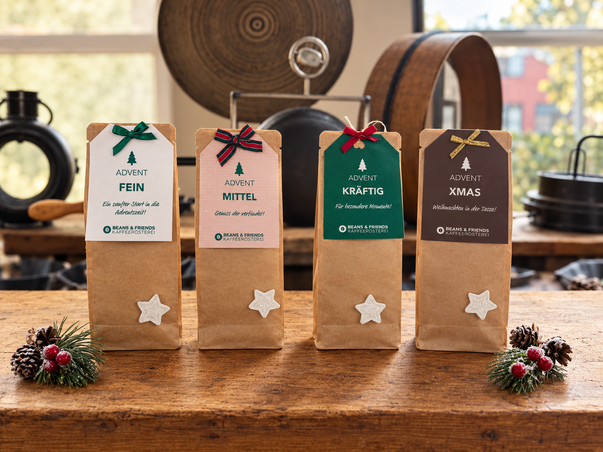 Vier Beans & Friends Adventspakete (Tassenfilter - Coffee Drip) in braunen Geschenktüten mit farbigen Anhängern und weihnachtlicher Dekoration.